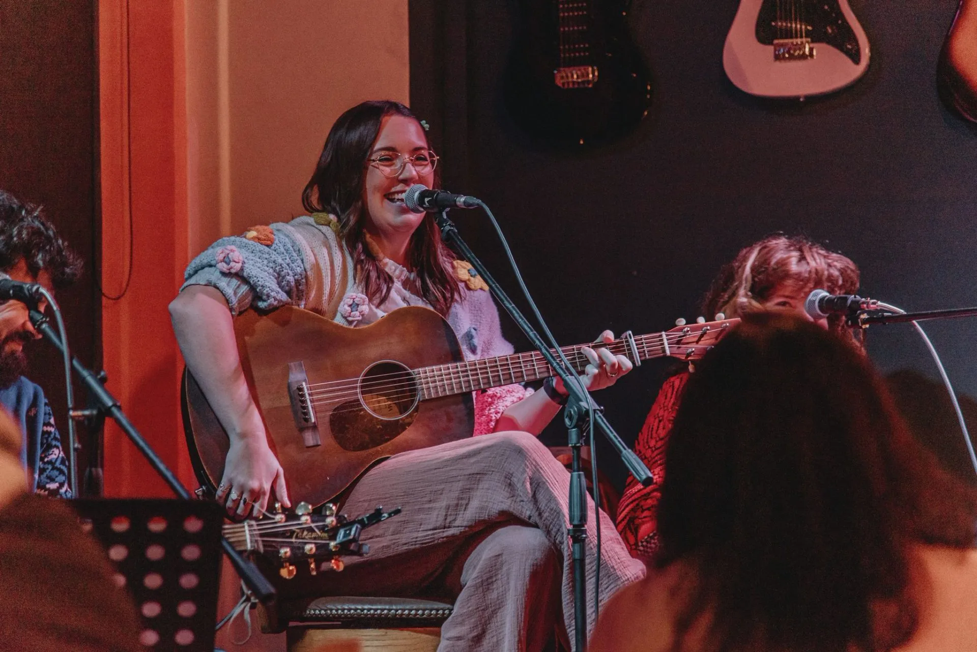 Lucy May Walker performing with an acoustic guitar